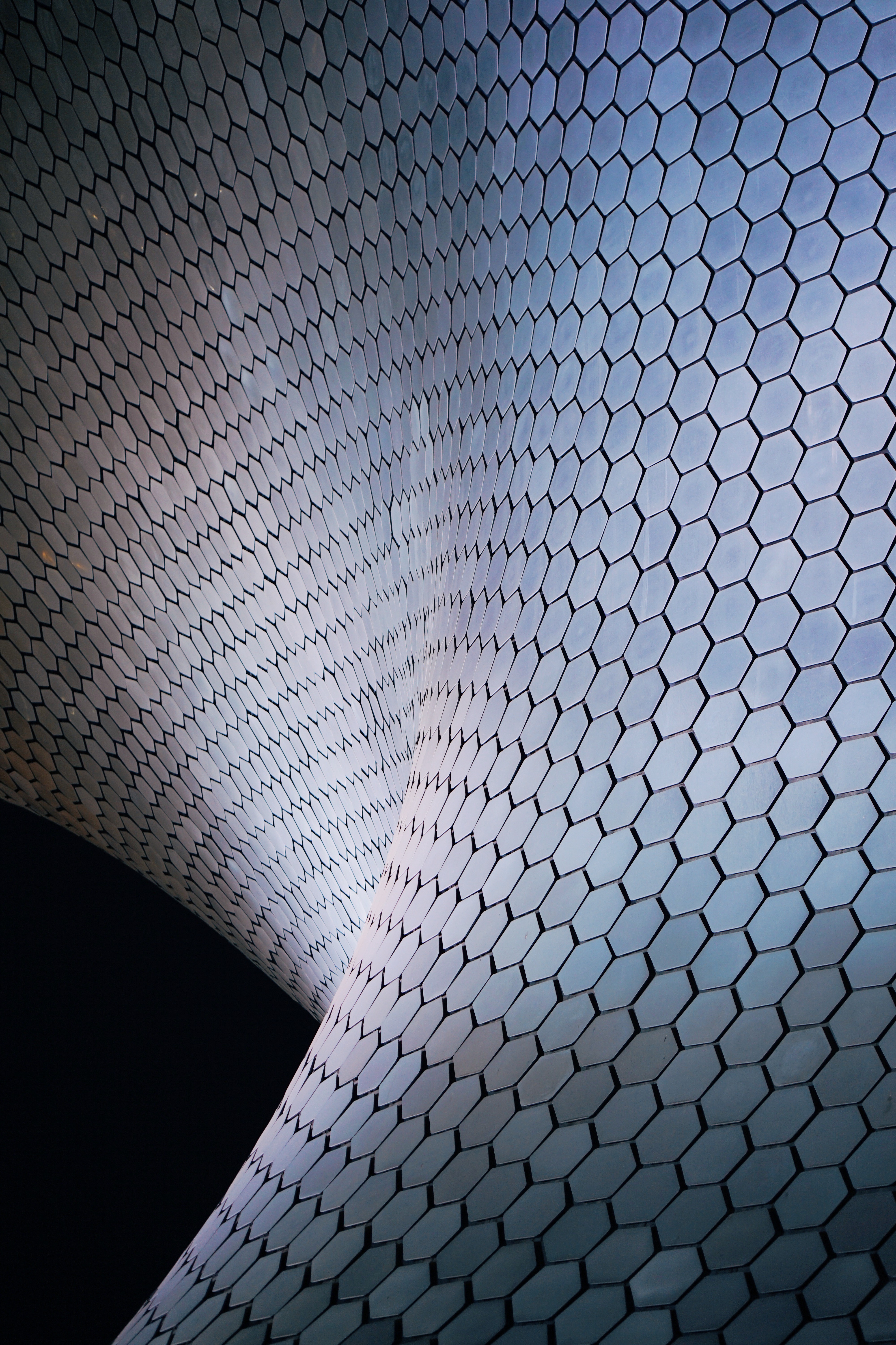 Curving walls covered in reflective hexagonal panels