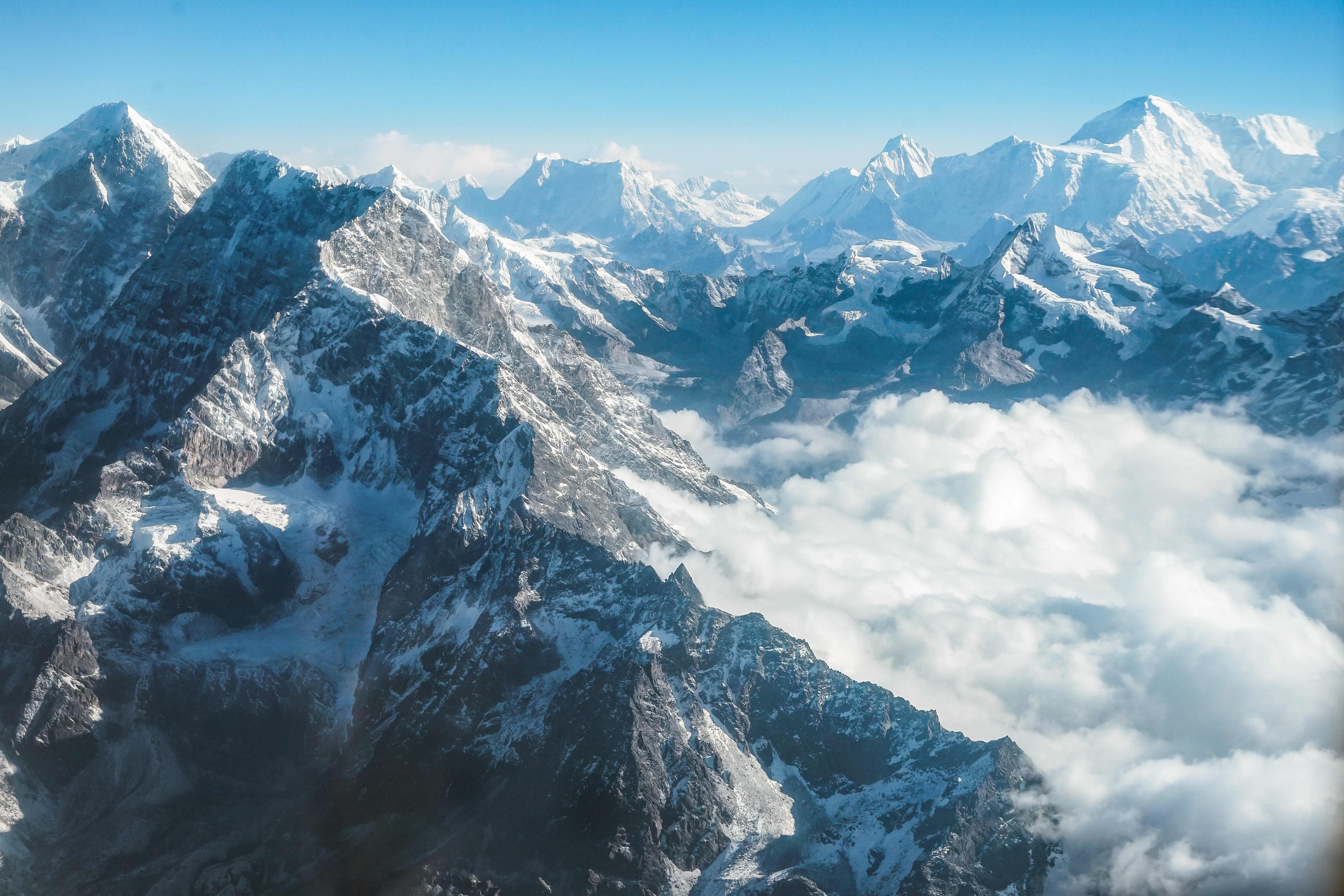 Snow-covered Himalayan peaks rising above the clouds