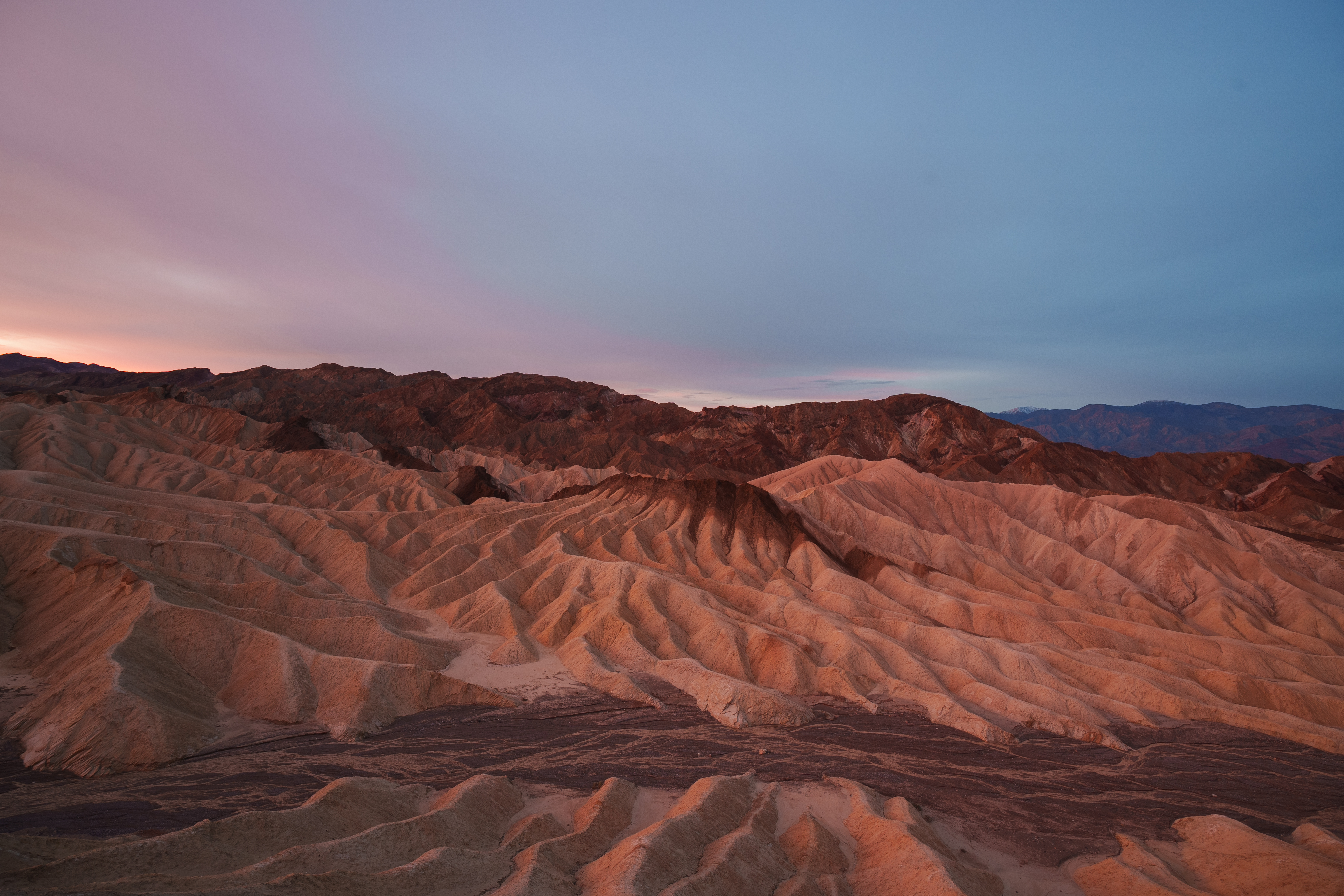 Layered desert ridges glowing pink before sunrise