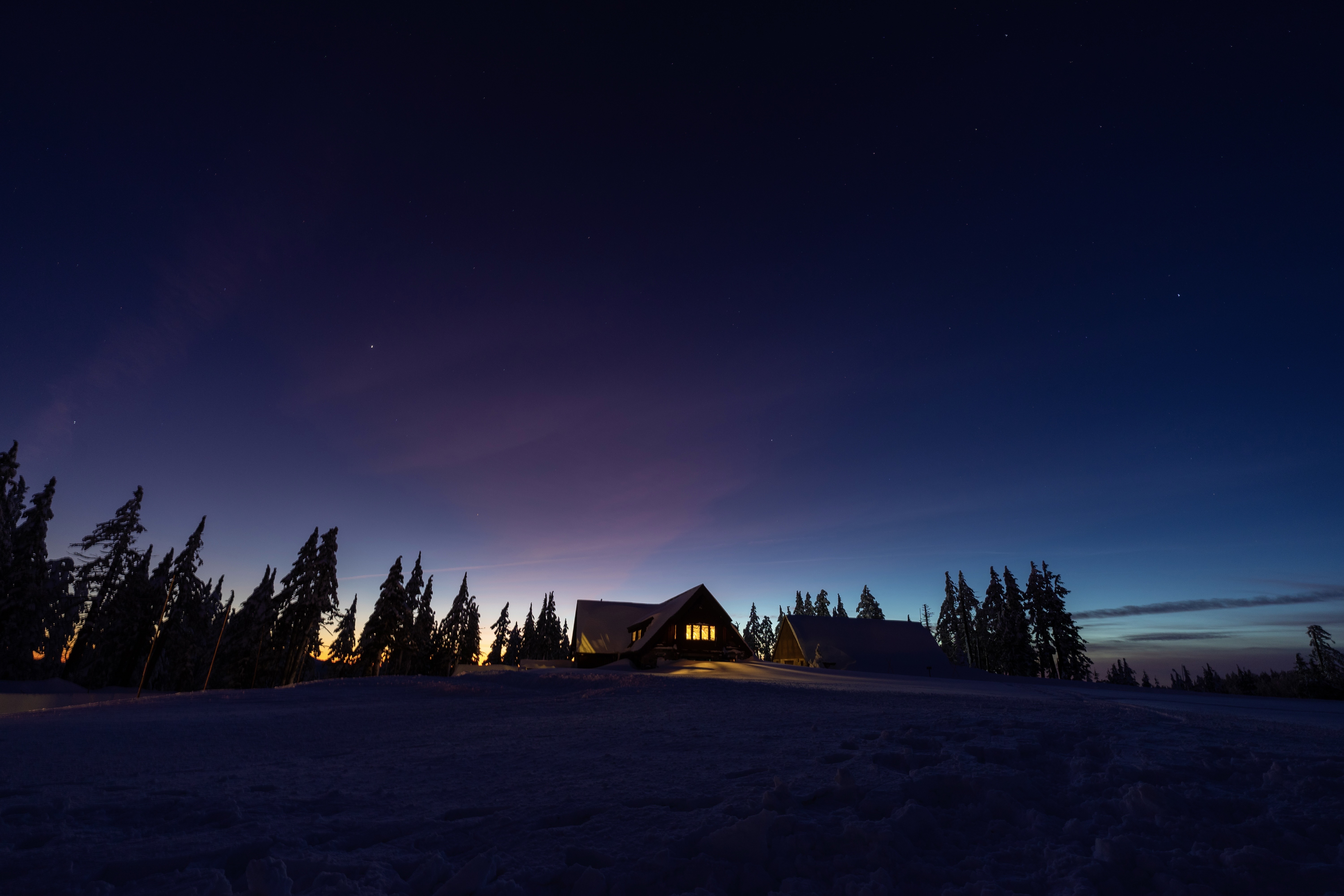 A snow-covered lodge beneath a deep blue night sky