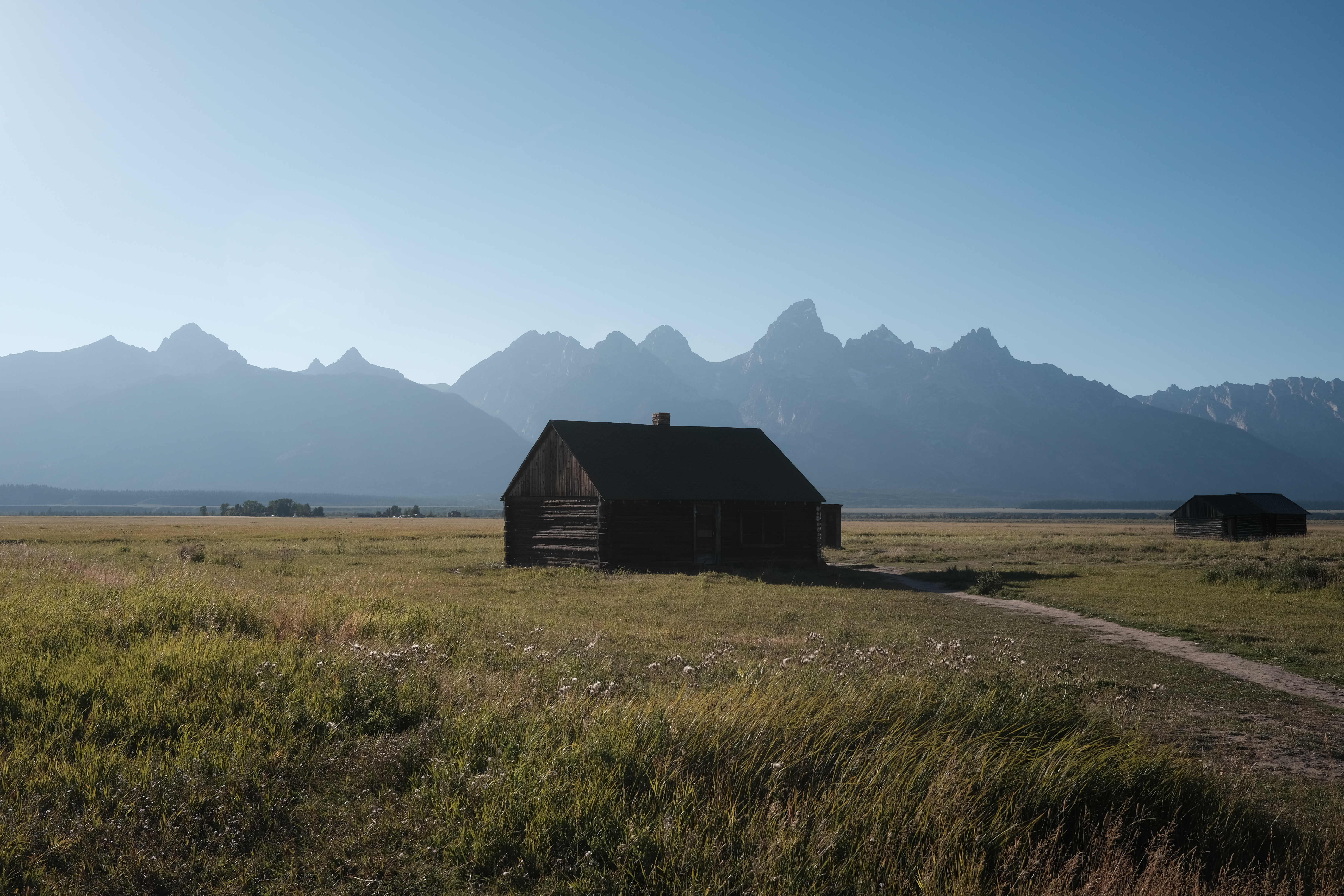 A weathered barn standing below the Teton Range