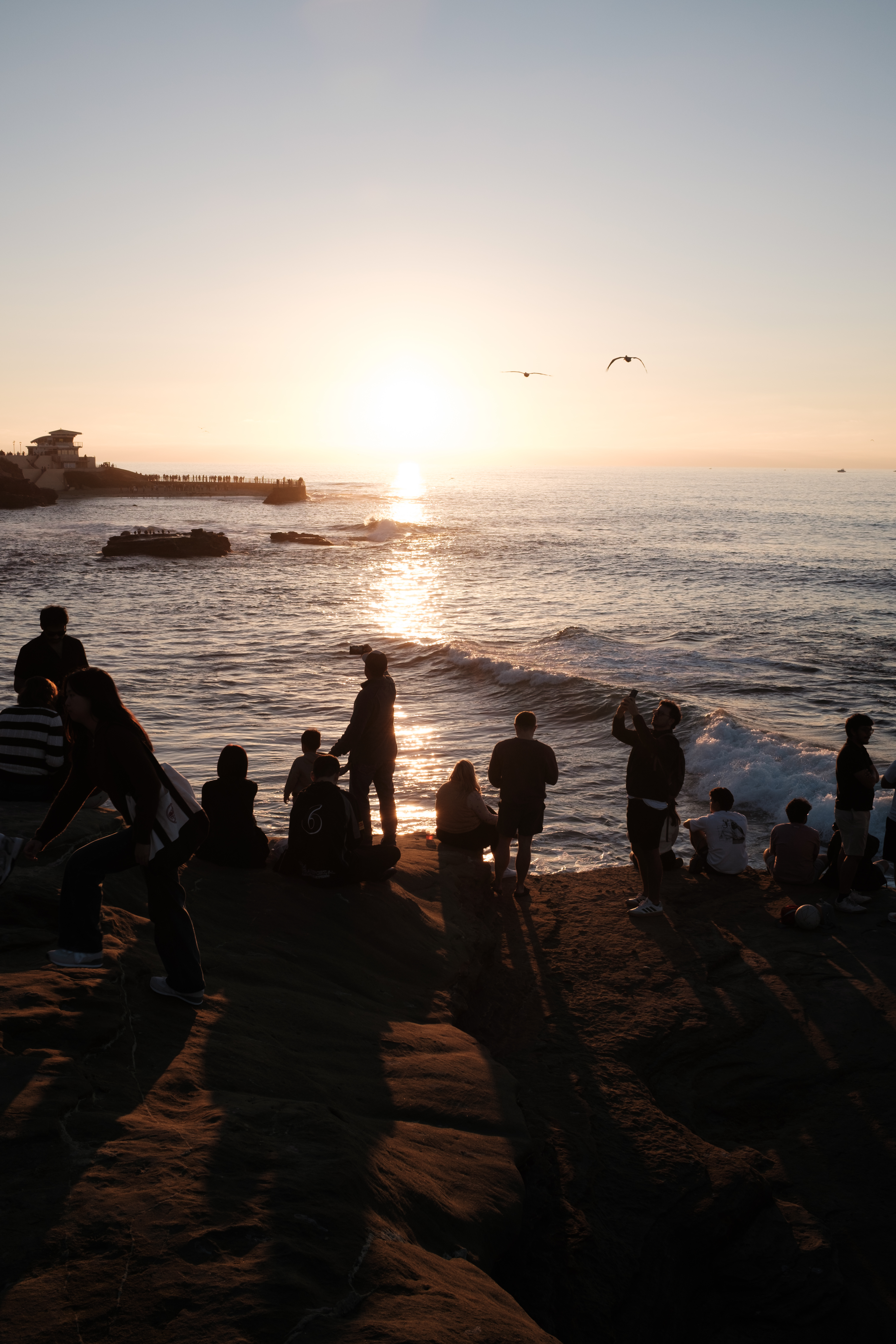 Visitors watching the sun set over the Pacific Ocean
